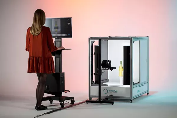 Mulher operando um estúdio automatizado de fotografia de produtos